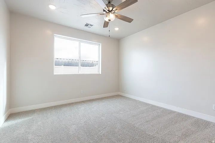 Unfurnished room with light colored carpet, a ceiling fan, and recessed lighting