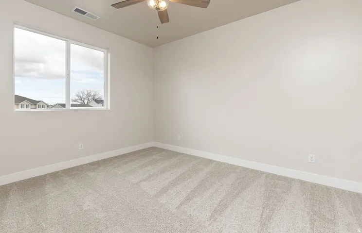 Empty room with light carpet and ceiling fan
