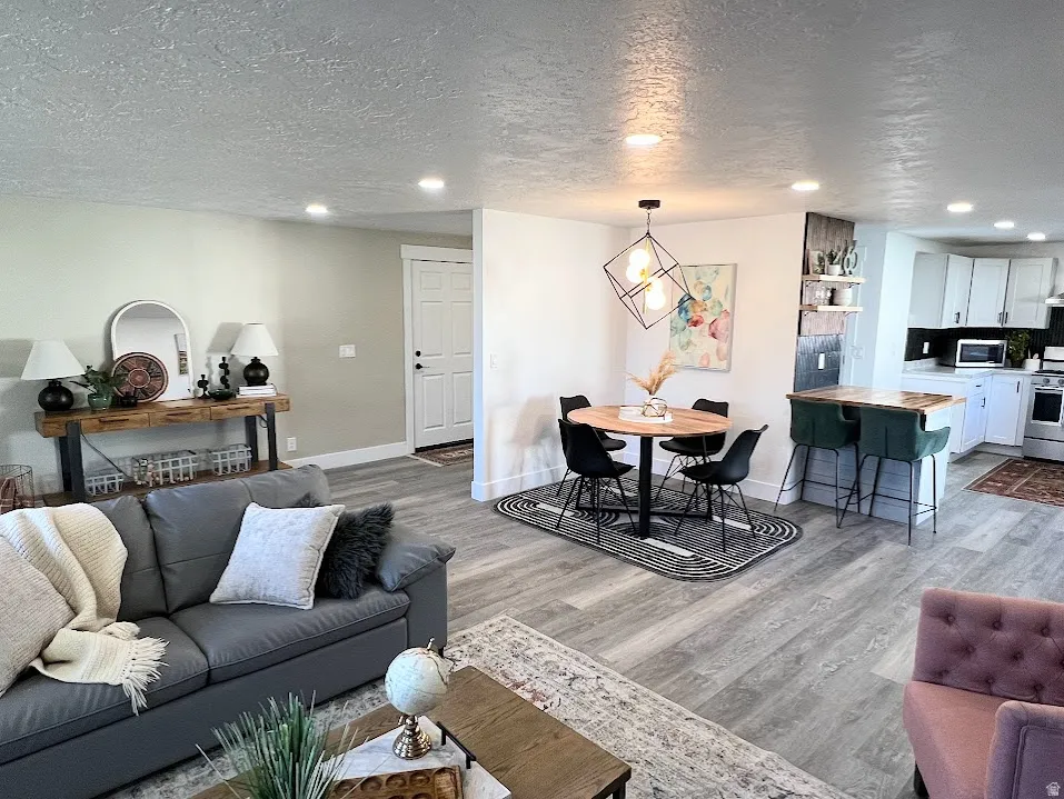 Living area with recessed lighting, a textured ceiling, and light wood-style floors