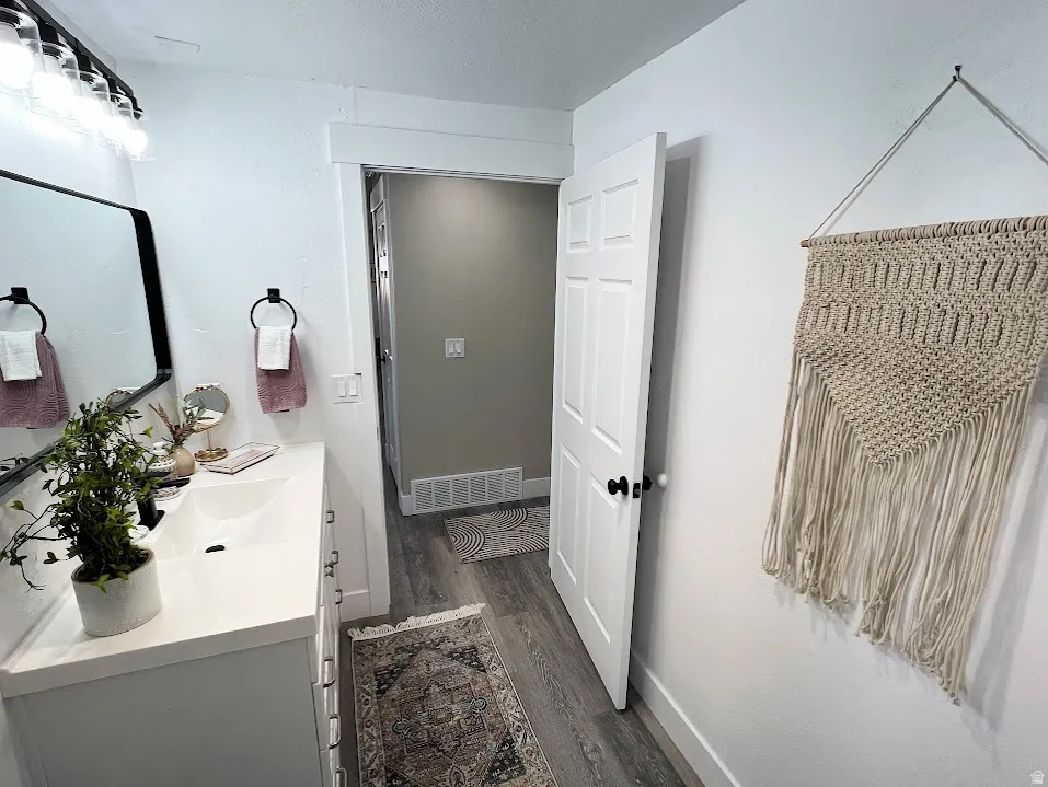 Bathroom with vanity and dark wood-type flooring