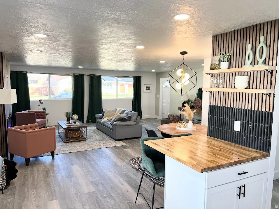Kitchen with butcher block counters, a breakfast bar area, open floor plan, pendant lighting, and open shelves