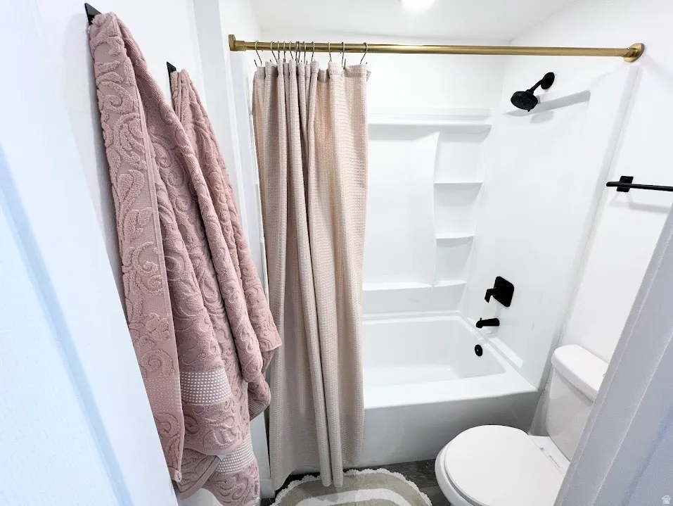 Bathroom featuring toilet and shower / bath combo