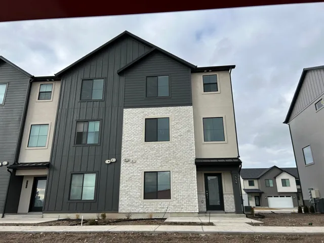 Modern inspired farmhouse featuring a standing seam roof, board and batten siding, and brick siding