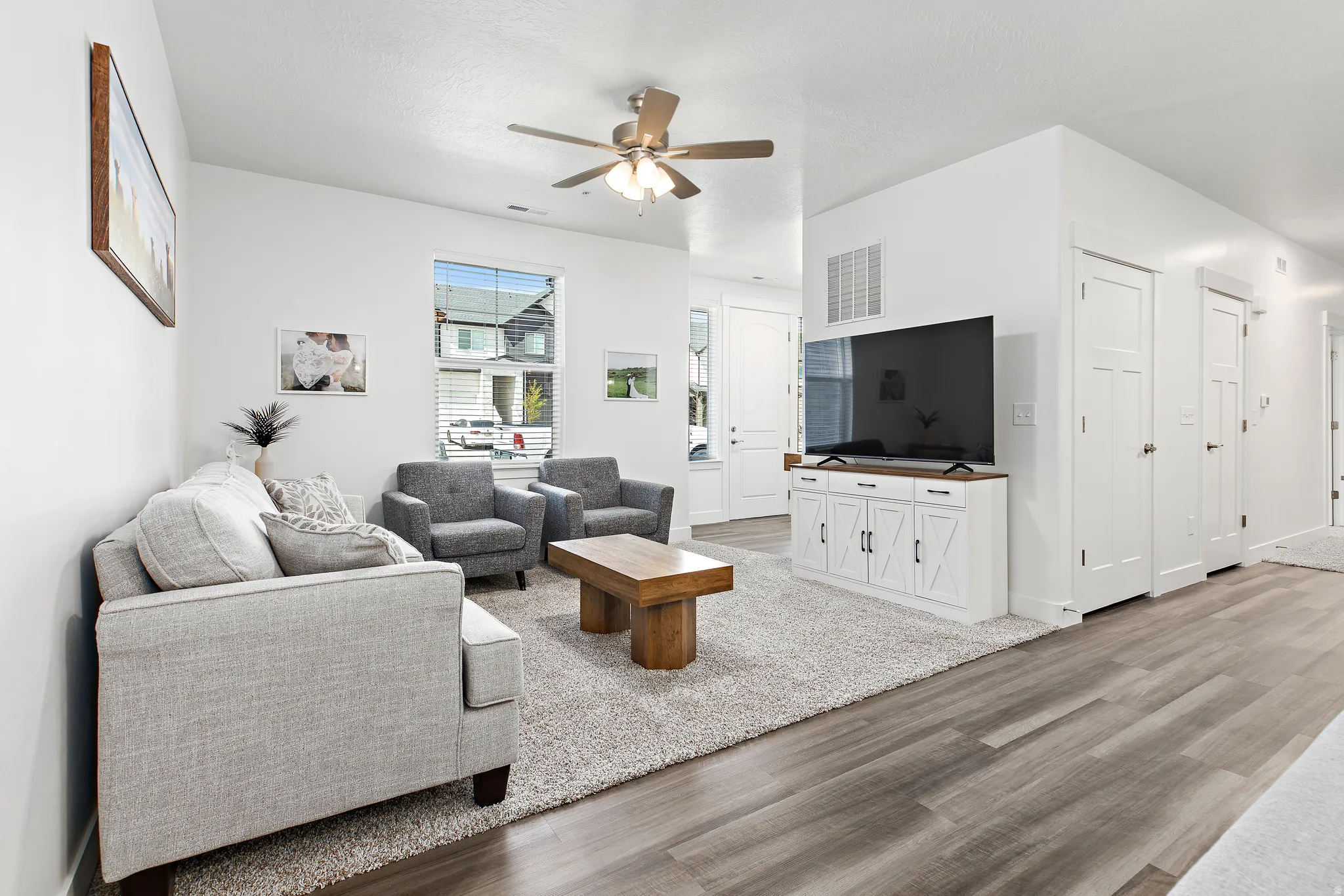 Living room with light wood-type flooring and ceiling fan