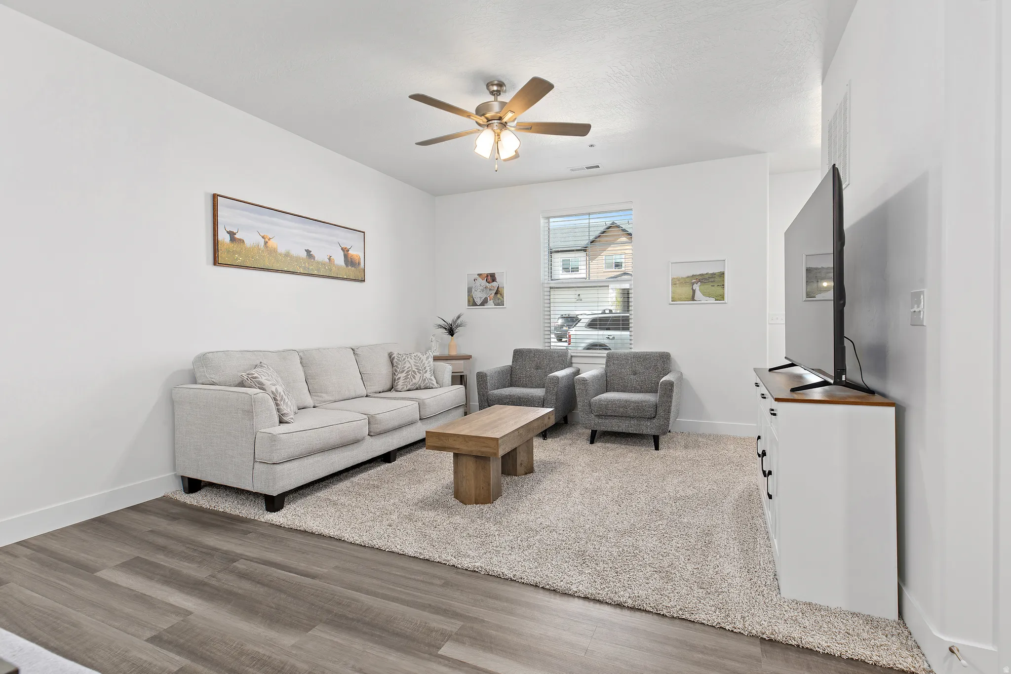Living room with light wood-style floors and ceiling fan