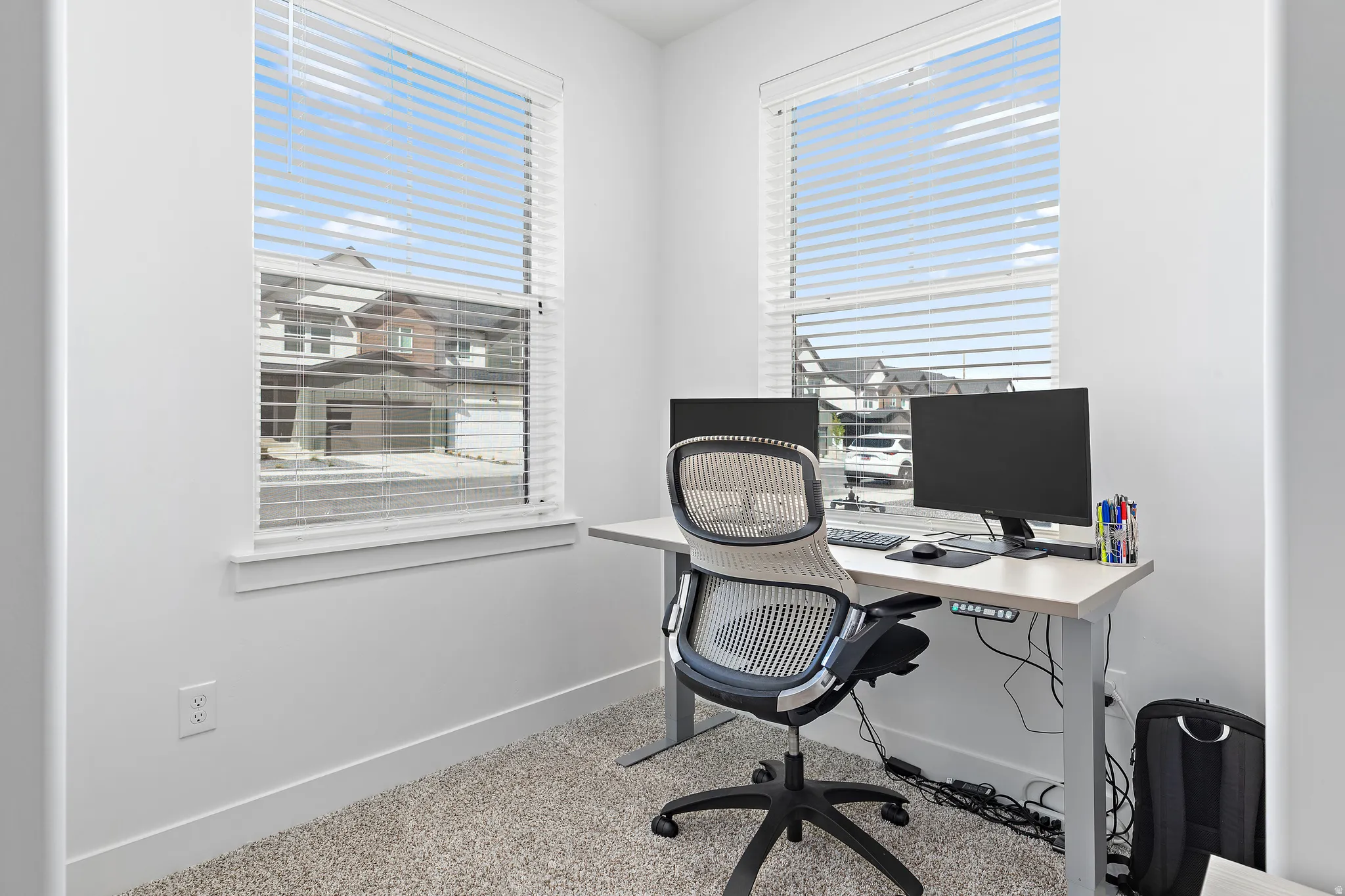 Office area with baseboards and light carpet