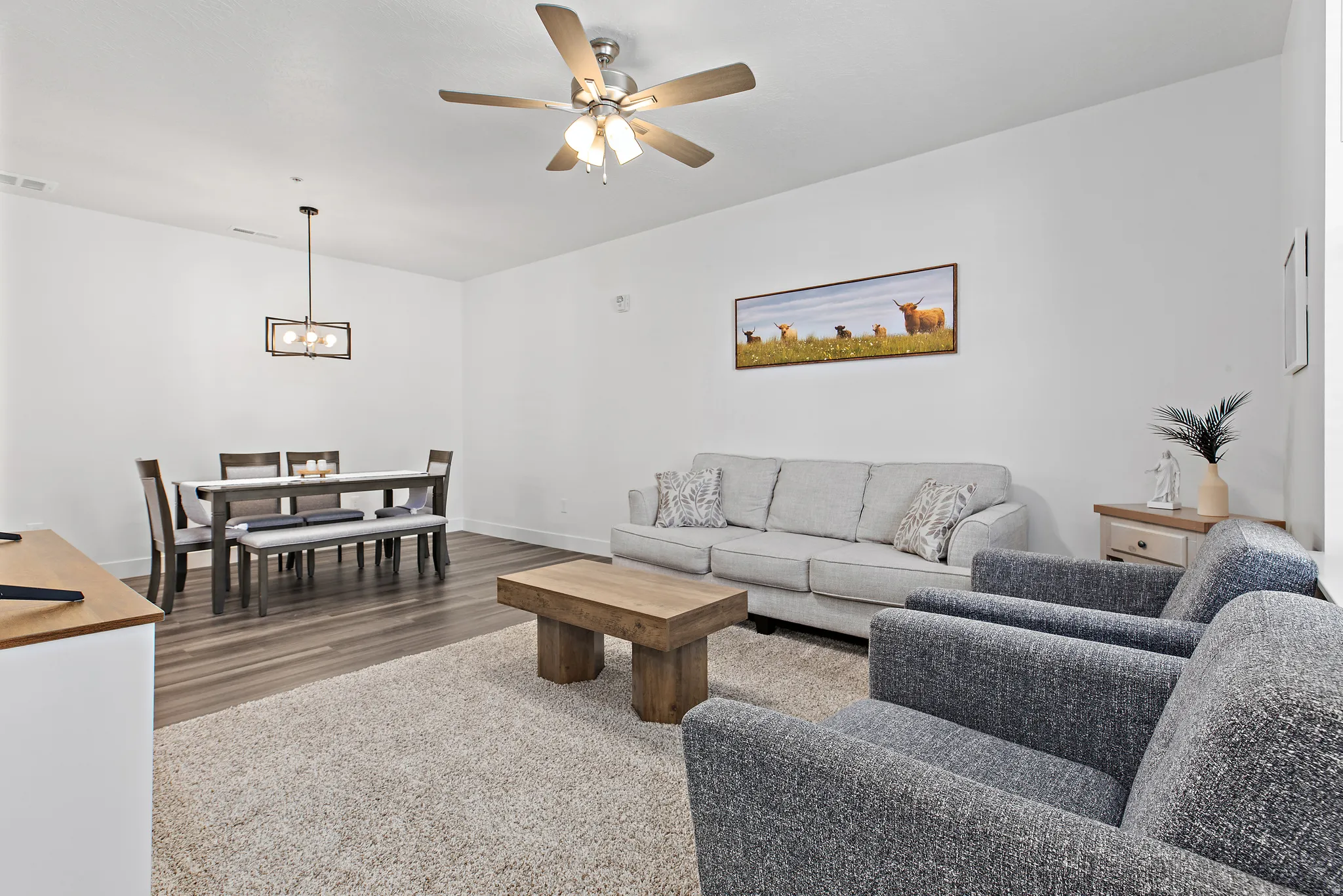 Living room featuring a ceiling fan and dark wood-style floors
