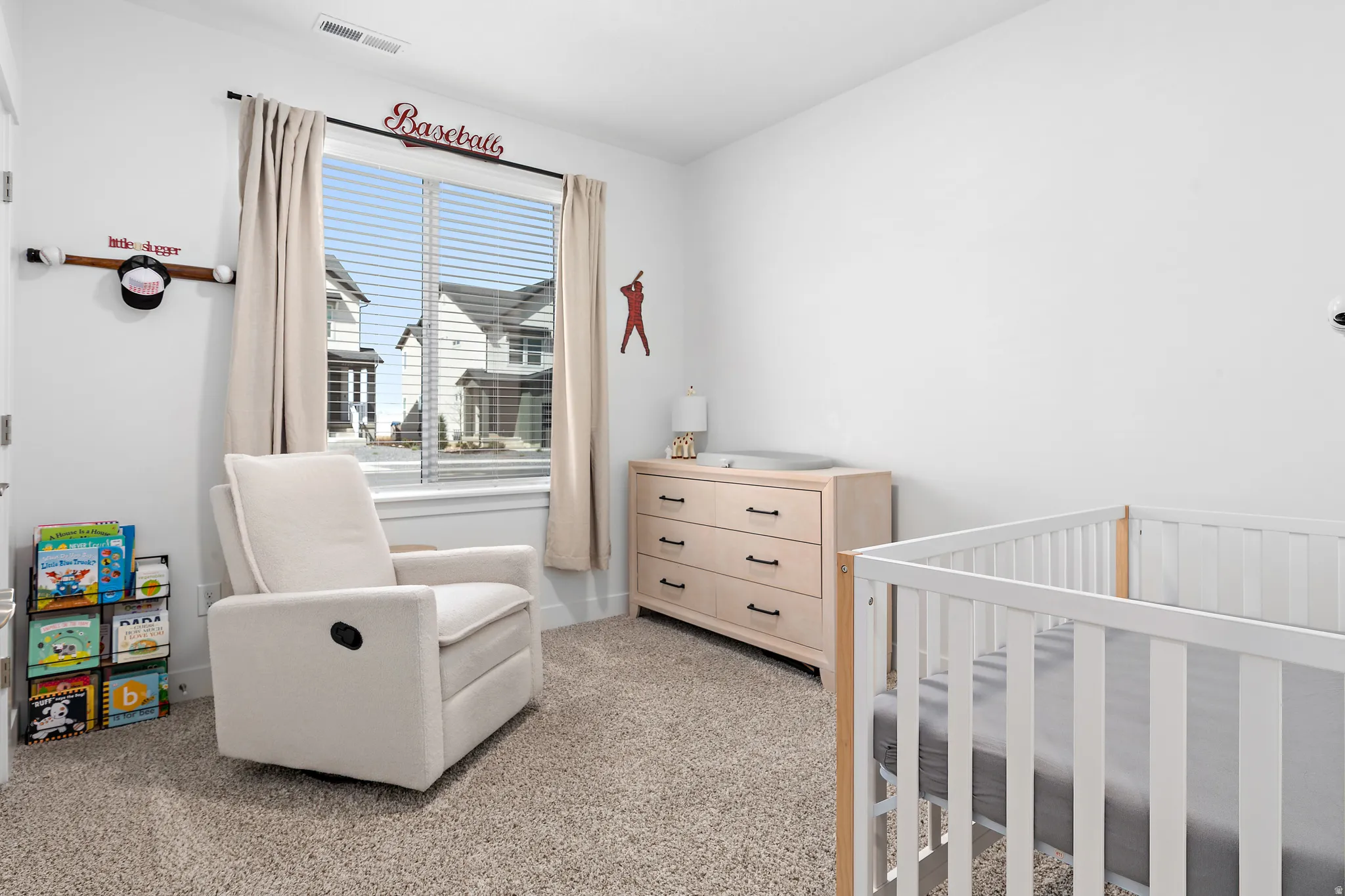 Bedroom featuring a crib and light carpet