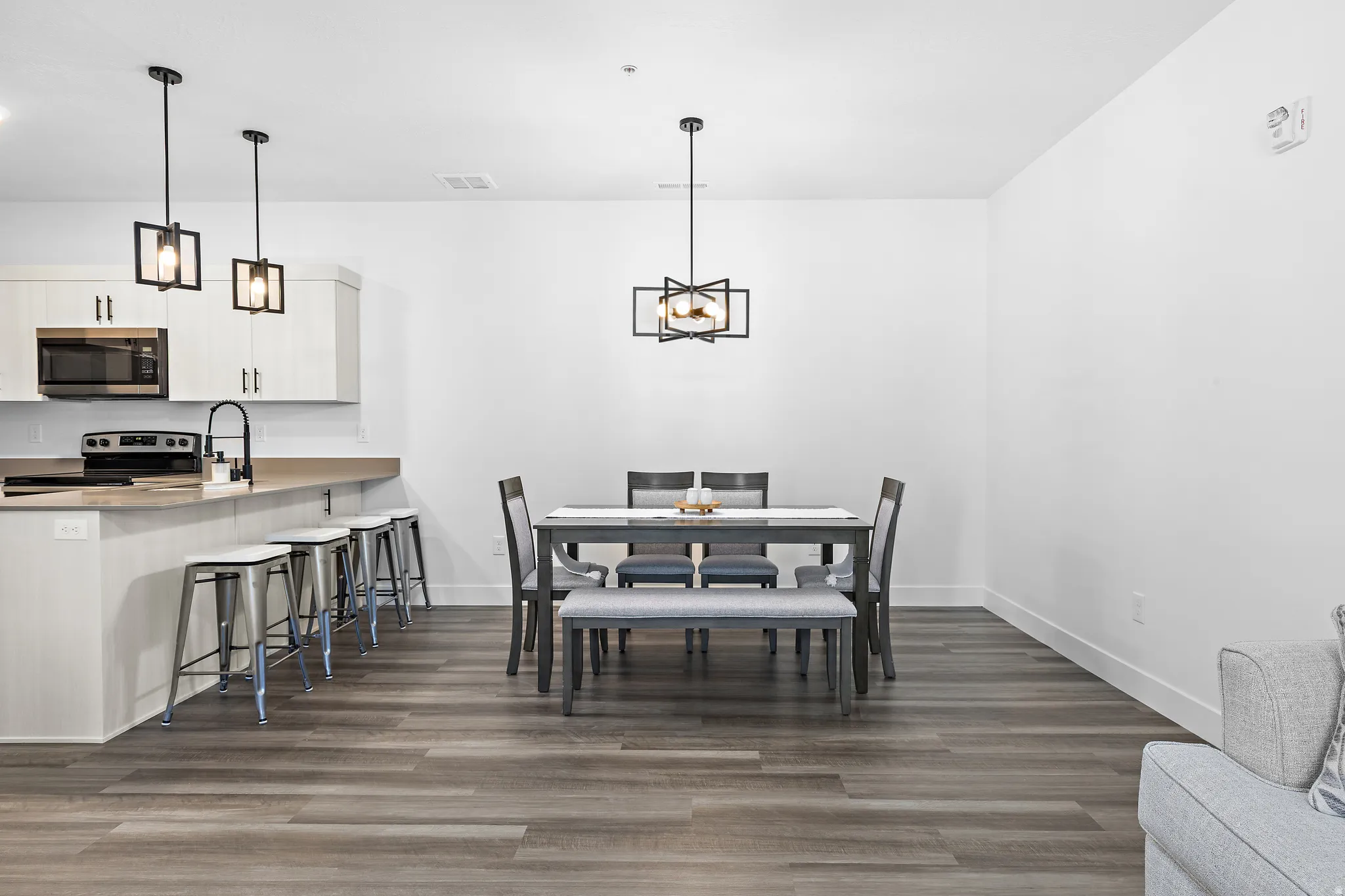 Dining room with dark wood-style floors and hanging lights