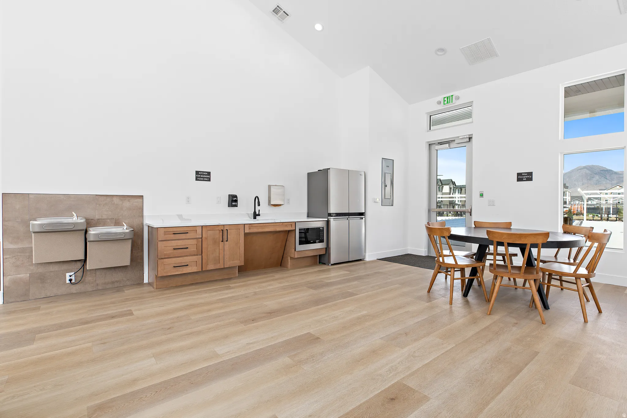 Kitchen with stainless steel appliances, wood finish cabinetry, recessed lighting, and lofted ceiling