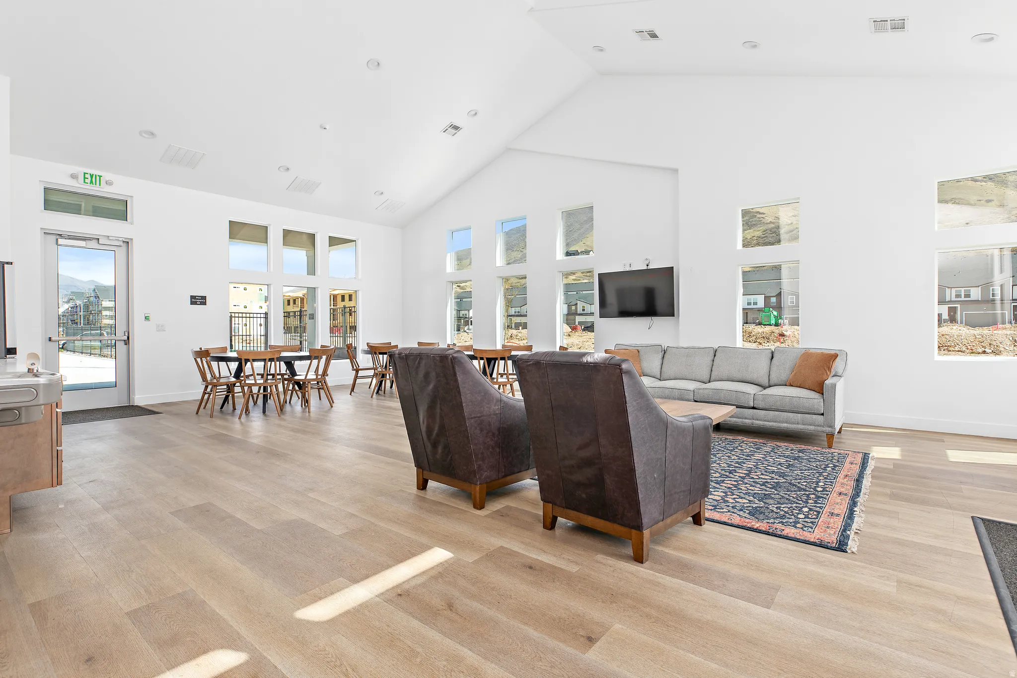 Living room featuring light wood-style floors, lofted ceiling, and recessed lighting