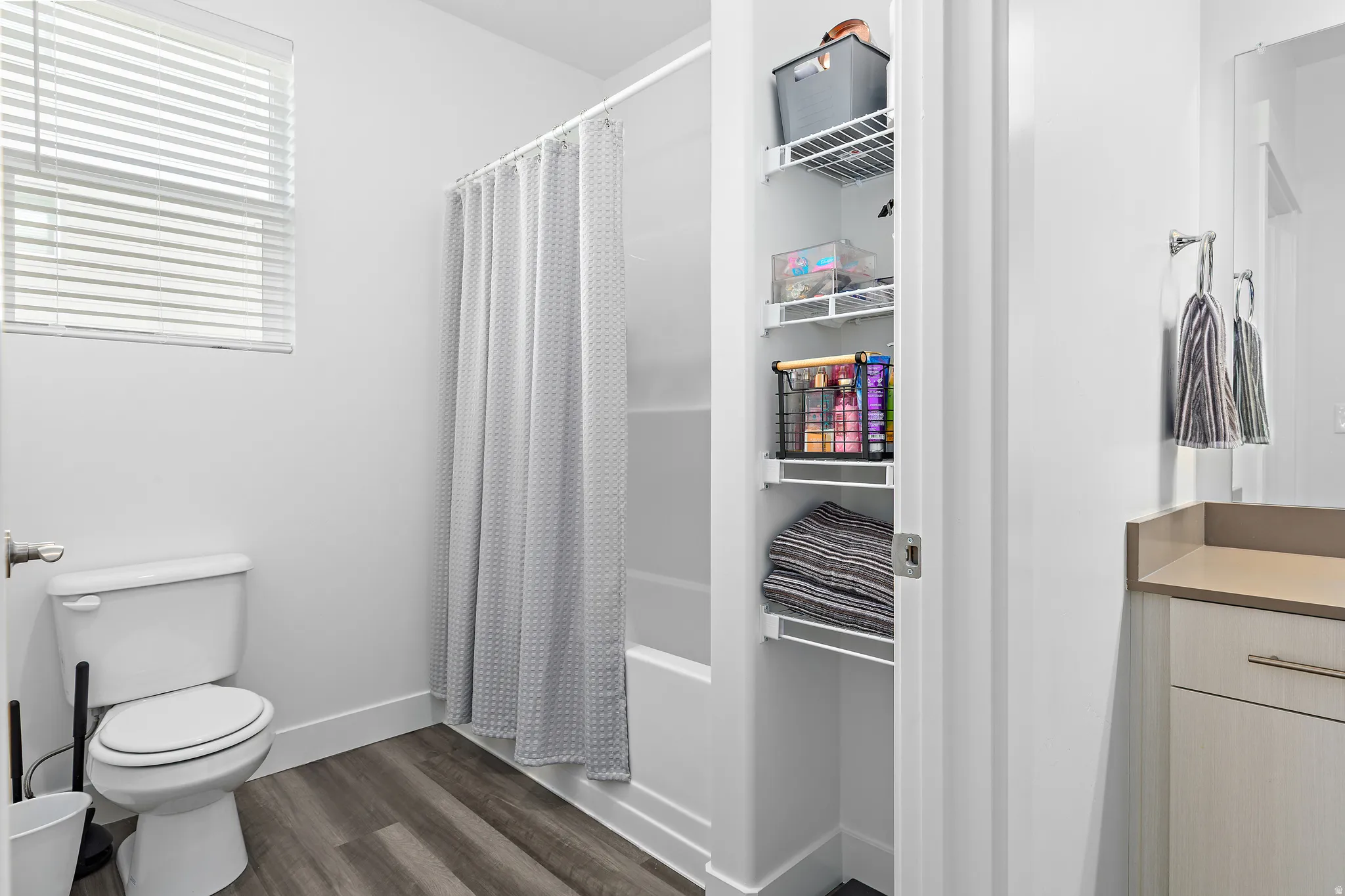 Bathroom featuring dark wood finished floors, vanity, and shower / bath combination with curtain