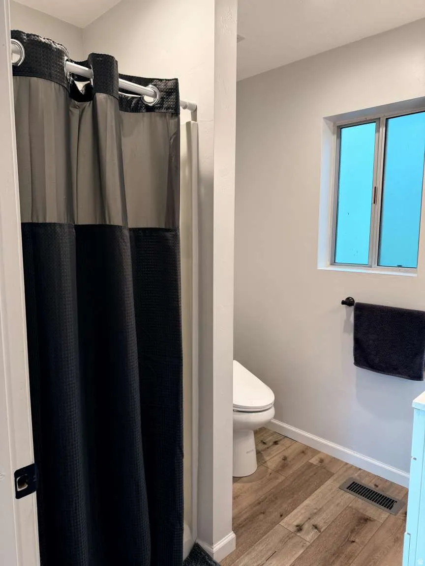 Bathroom featuring a stall shower, light wood-style floors, and vanity