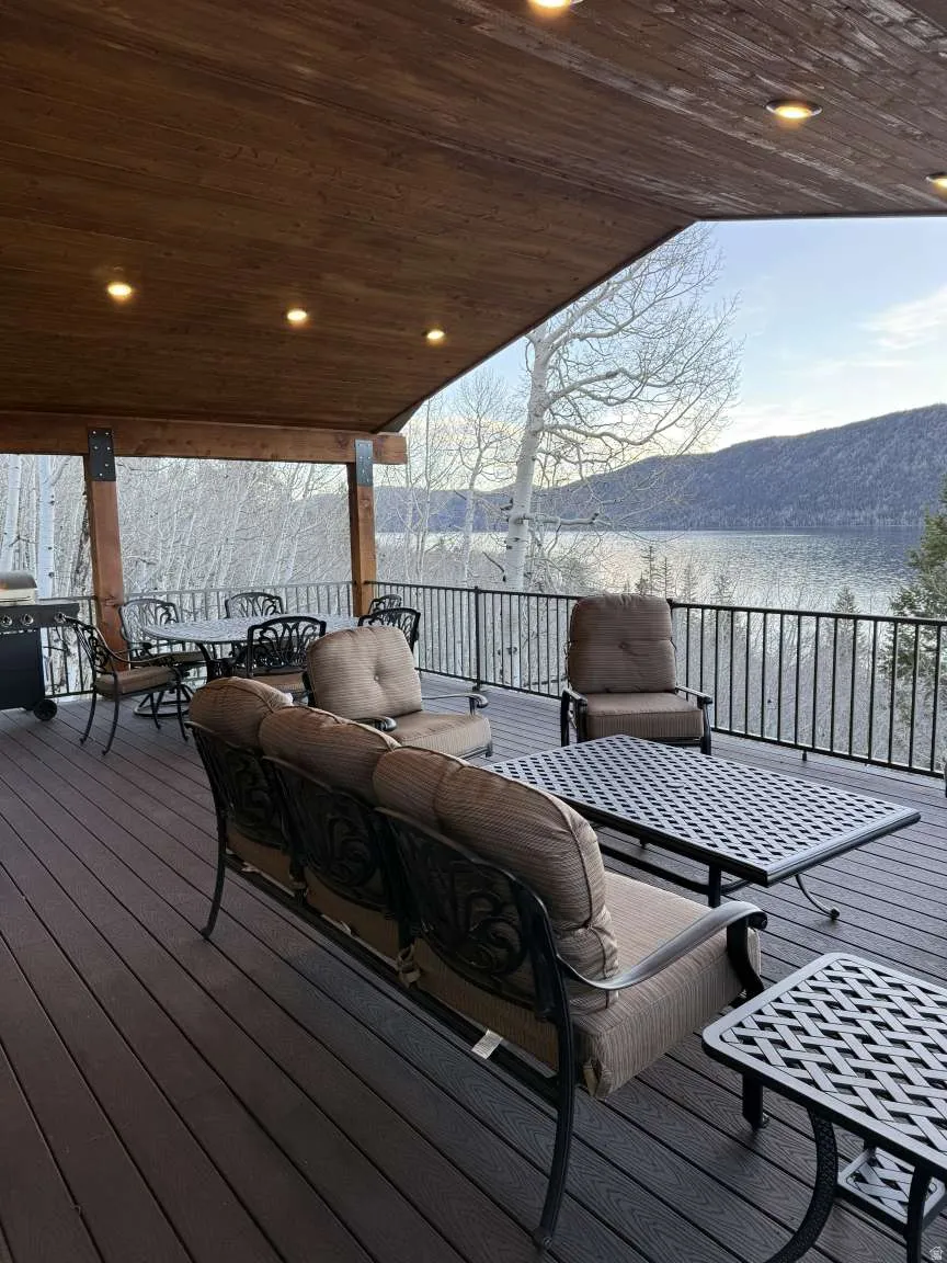Wooden deck with a water and mountain view and outdoor lounge area