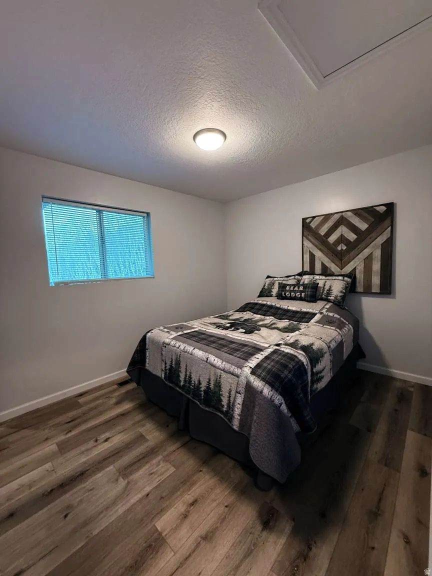 Bedroom featuring dark wood-type flooring and a textured ceiling