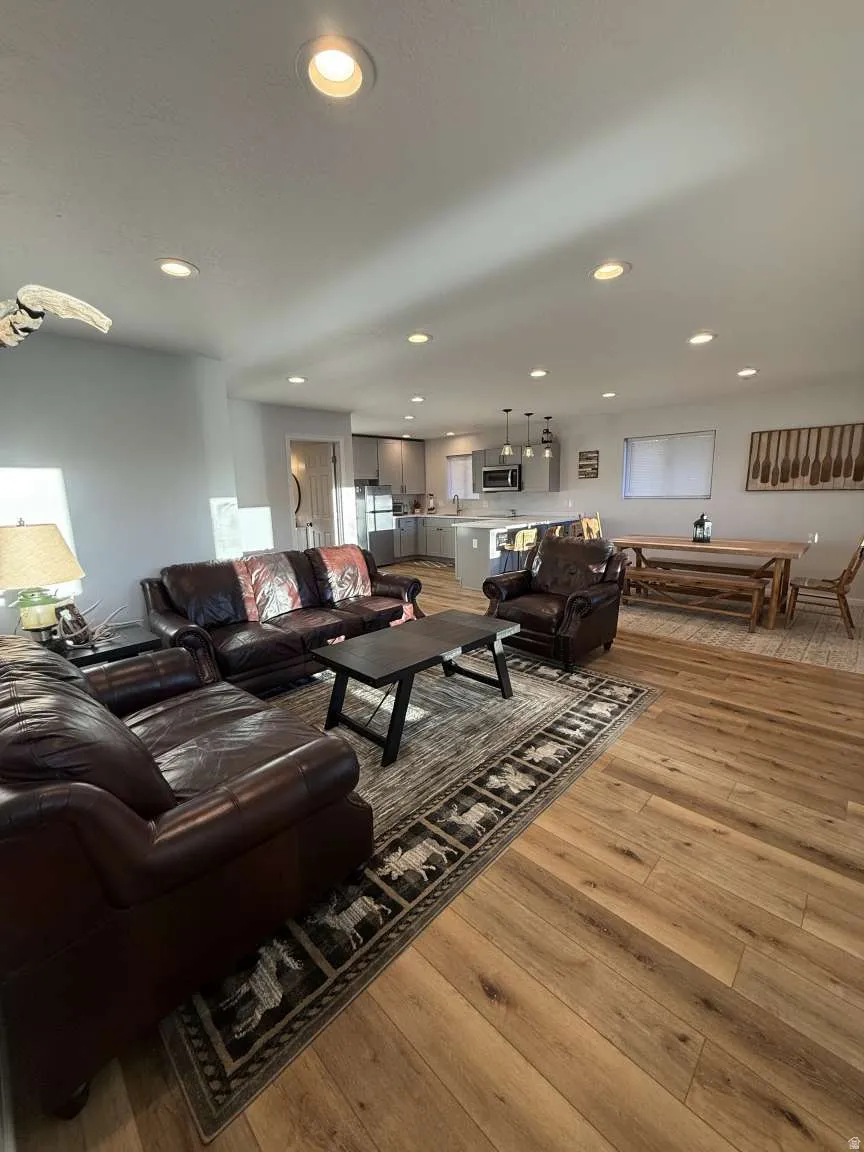 Living room with light wood-style flooring and recessed lighting
