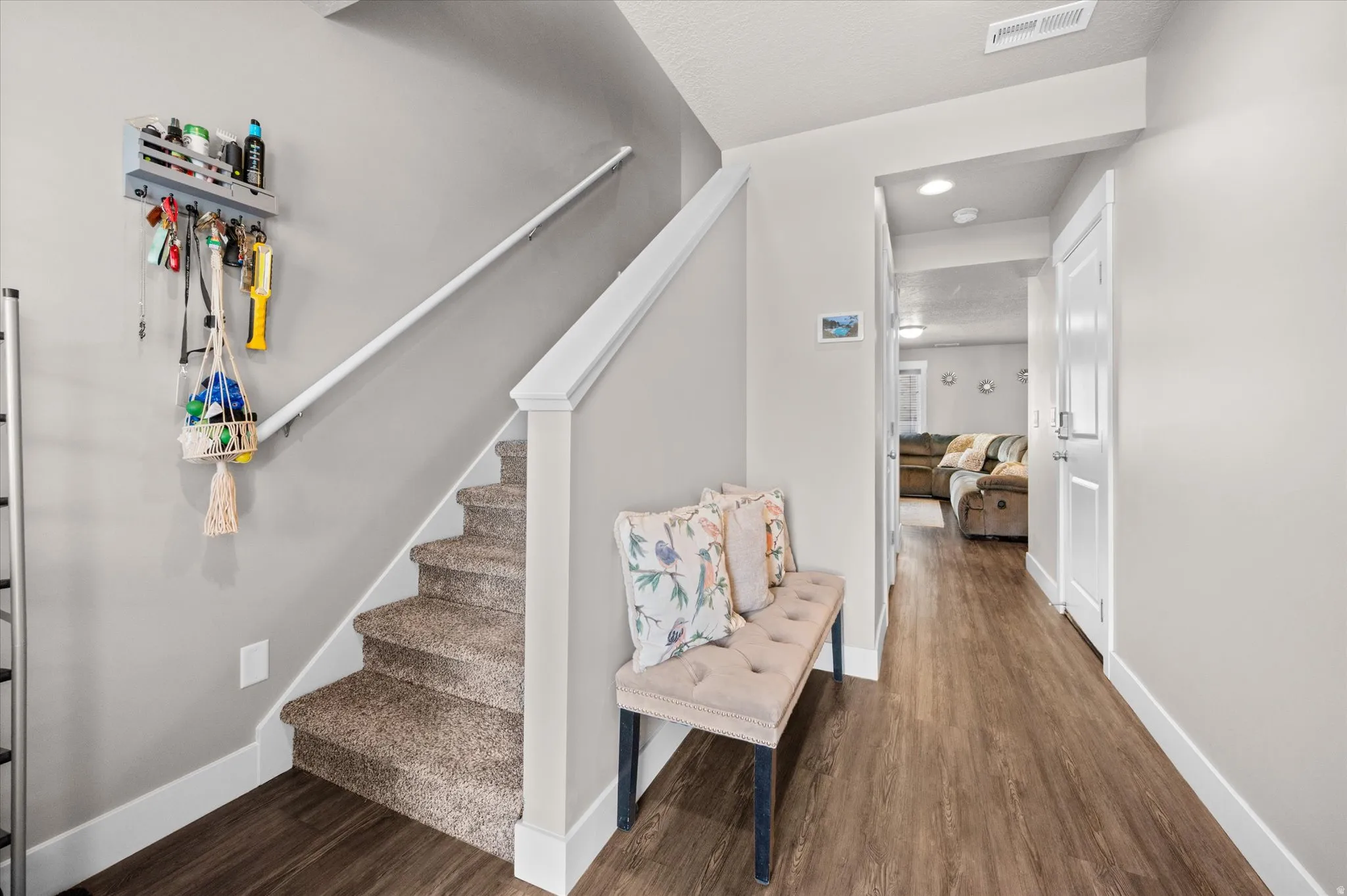 Welcoming entry with carpeted staircase, two-tone paint, and LVP flooring.