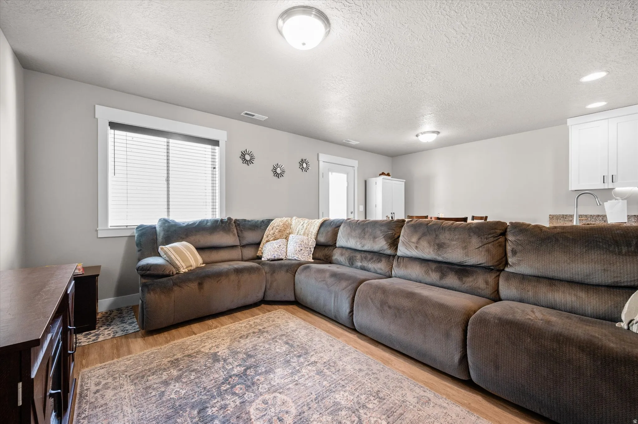 Spacious Family Room with LVP flooring, two-tone paint, and lots of natural light.