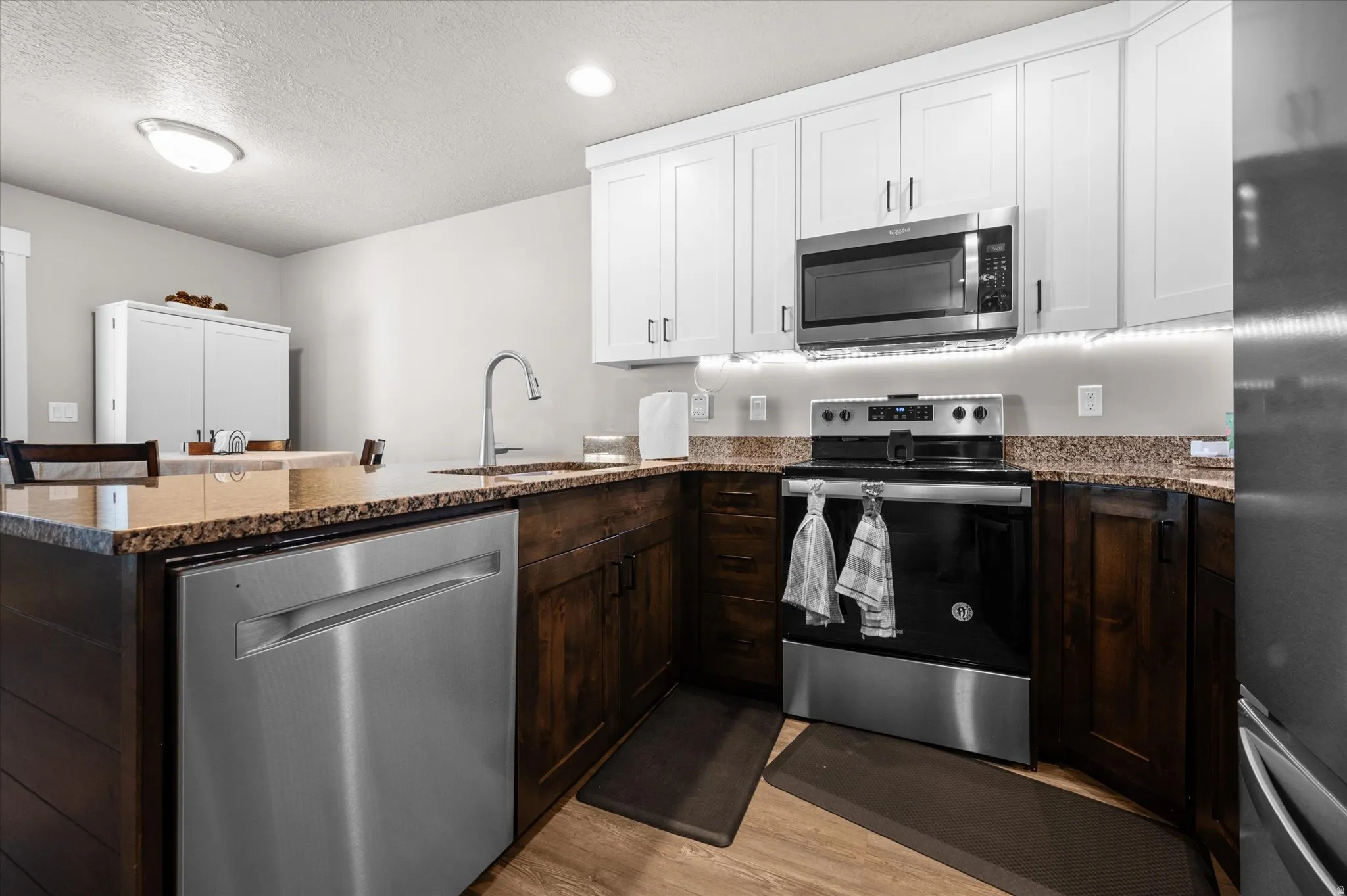 Kitchen featuring stainless steel appliances, granite countertops, and an island for extra eating space.