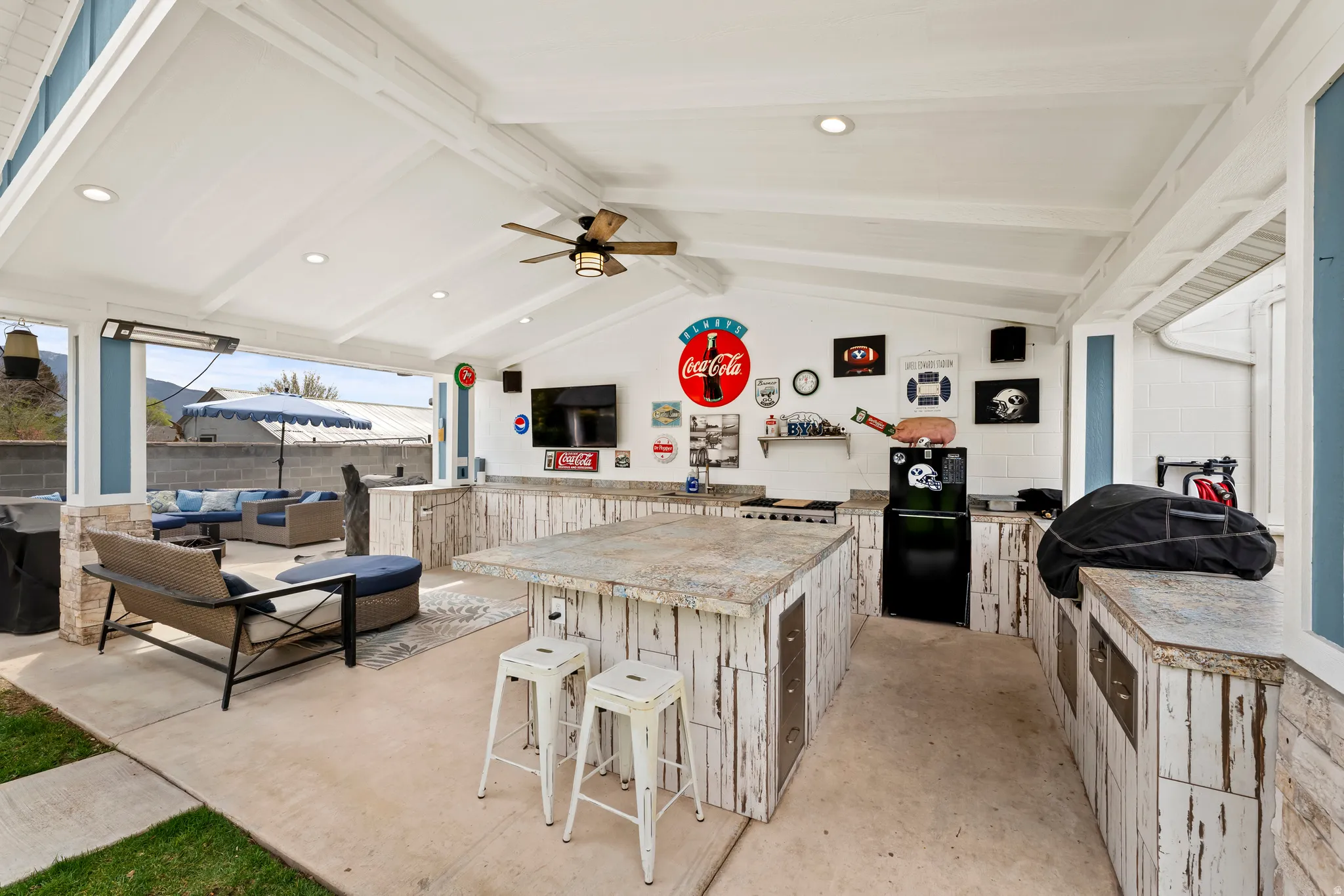 Outside kitchen complete with TV, refrigerator, seating,  grilling, etc.  Great for hosting game nights.