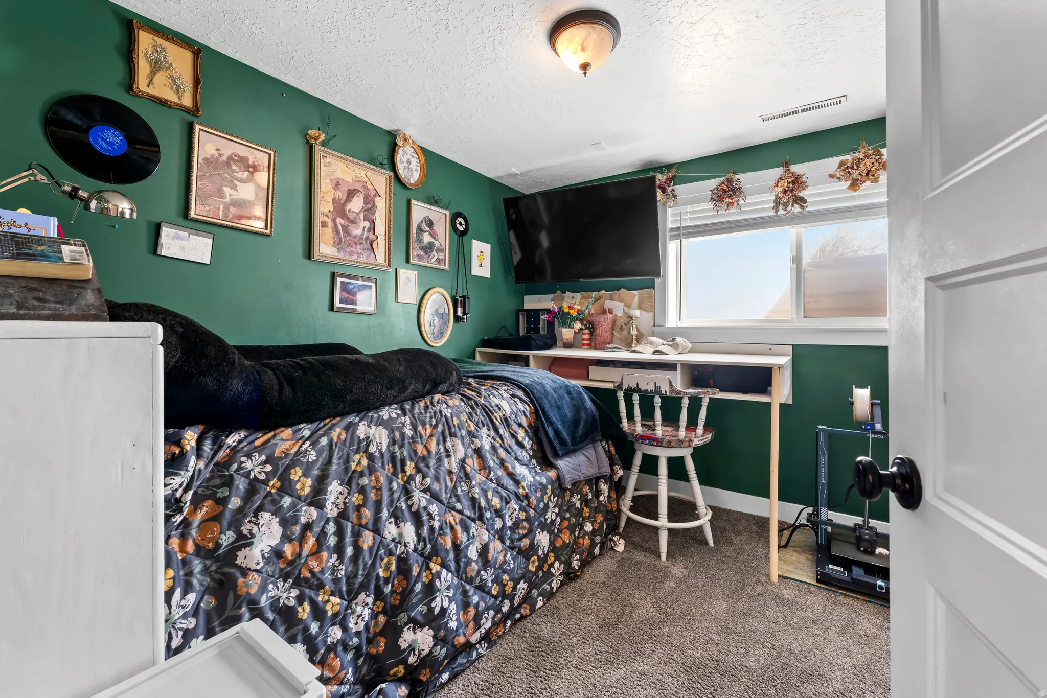 Bedroom featuring dark colored carpet and a textured ceiling