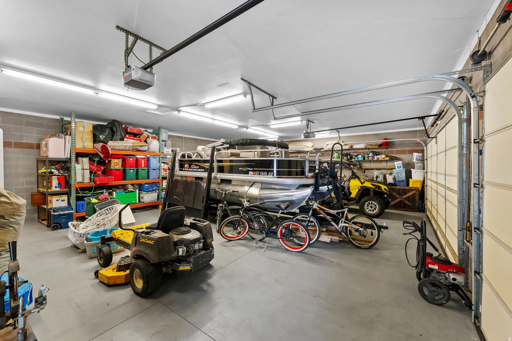 Garage featuring concrete block wall and a garage door opener