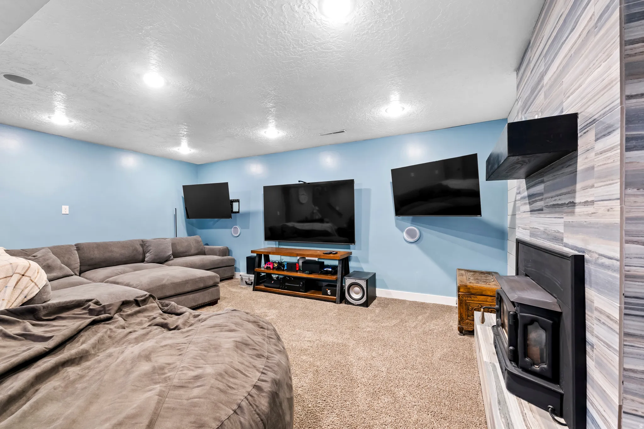 Carpeted living area featuring baseboards and a textured ceiling