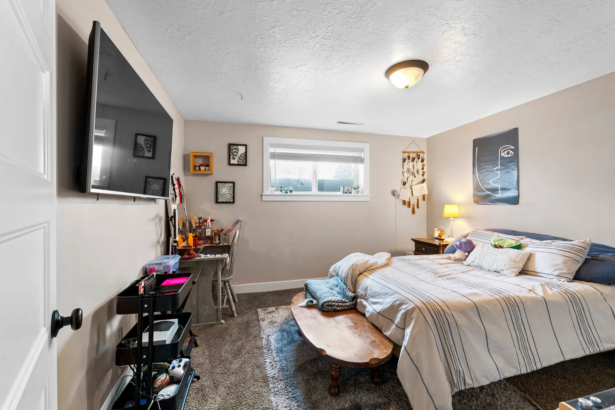 Bedroom with a textured ceiling and dark carpet