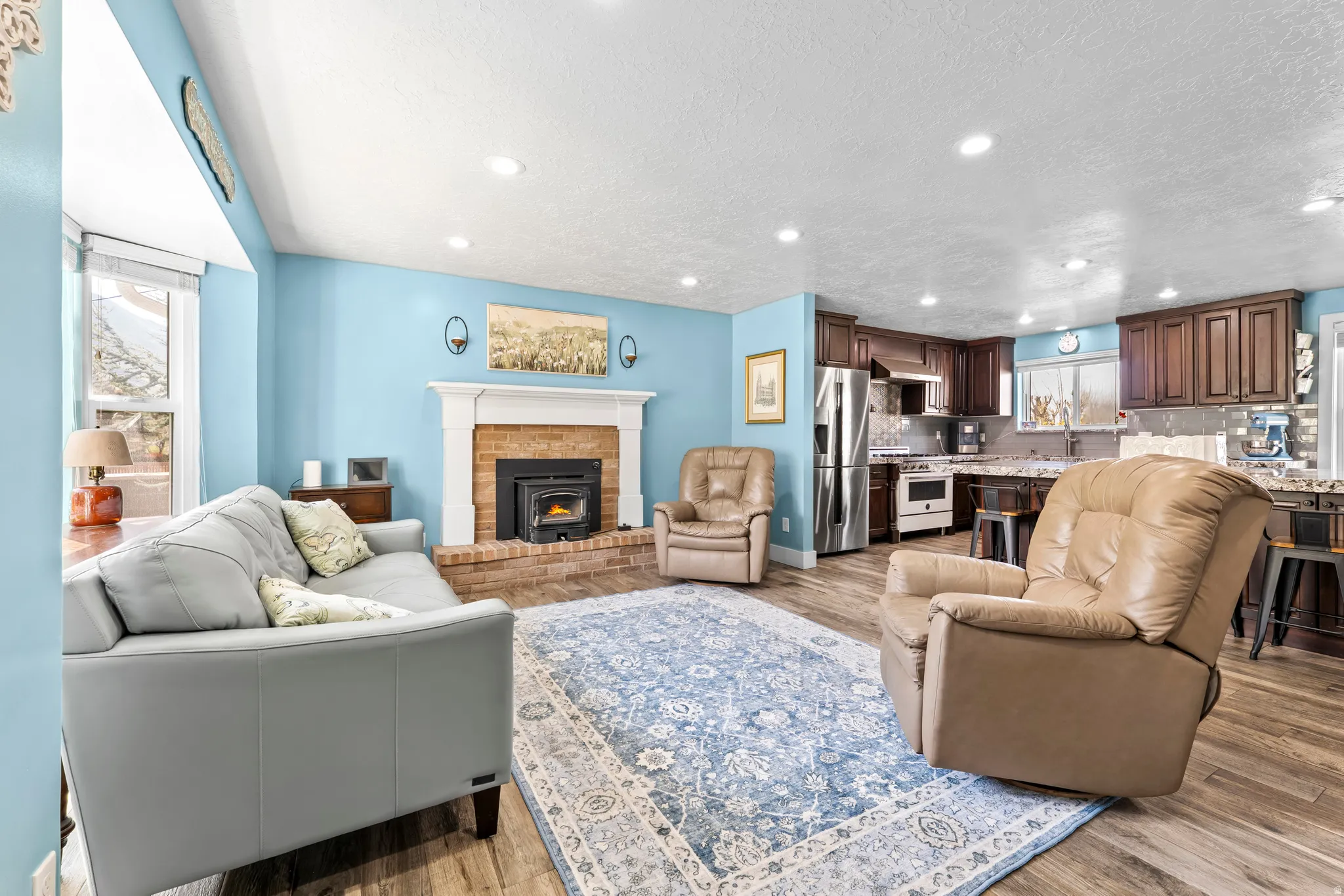 Living room with recessed lighting, light wood finished floors, and a textured ceiling