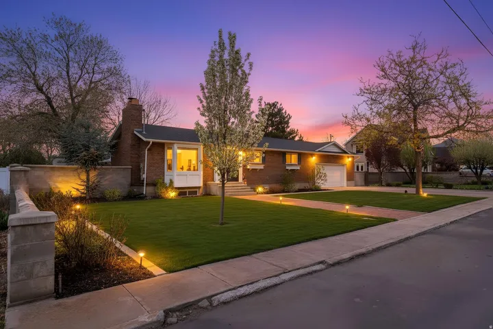 Single story home with a front yard, a 2 car attached garage, brick siding, concrete driveway, and a chimney