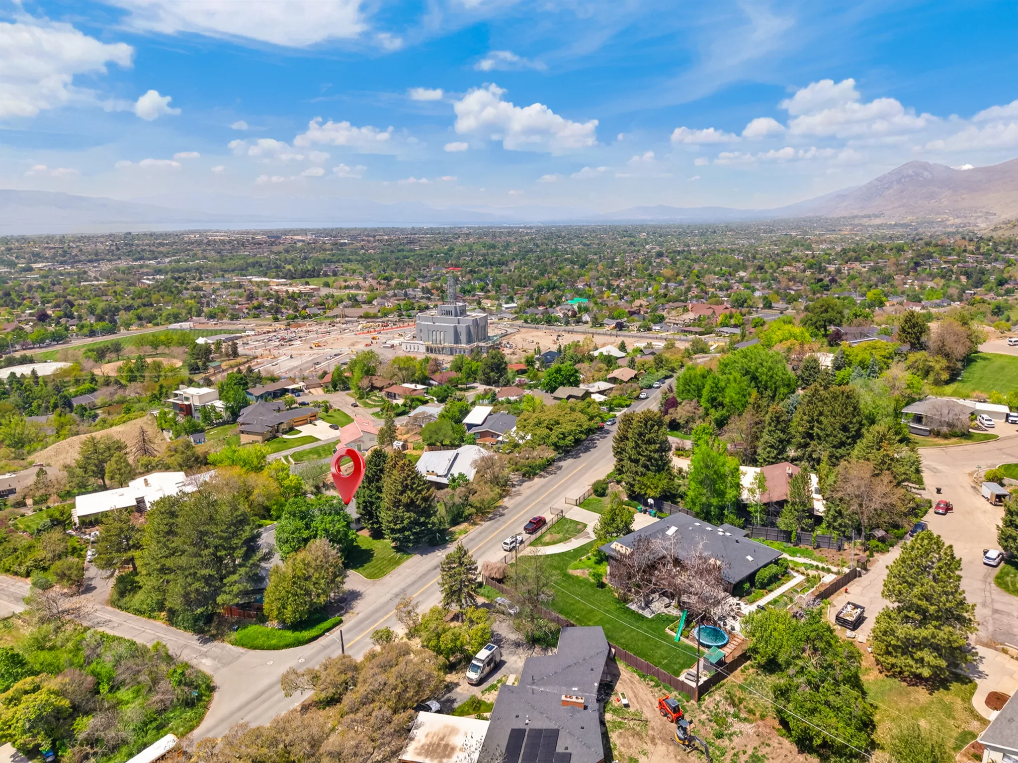 Expansive residential area with mature tree coverage and visible mountain backdrop