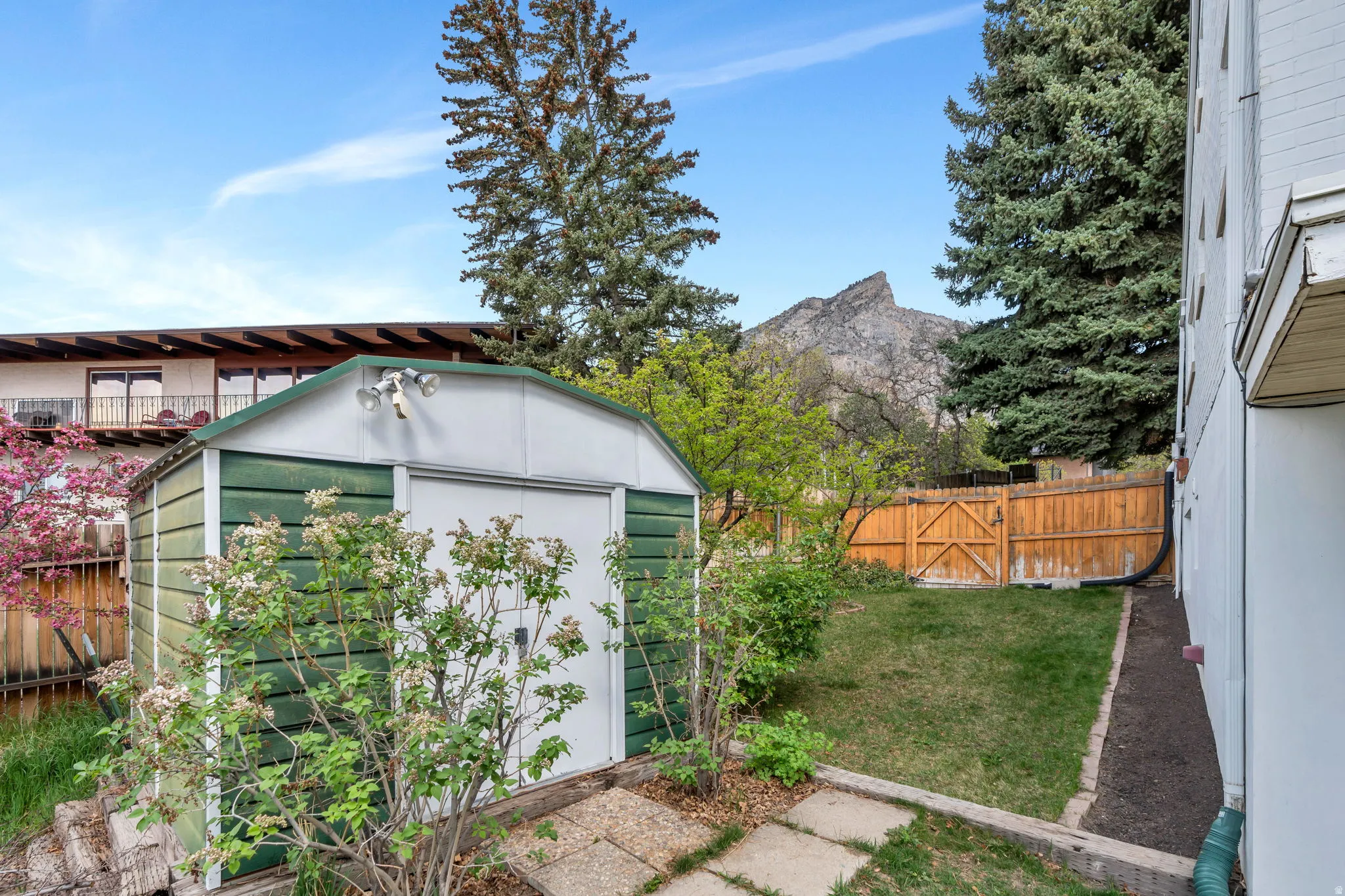 View of shed with a fenced backyard, a gate, and a mountain view