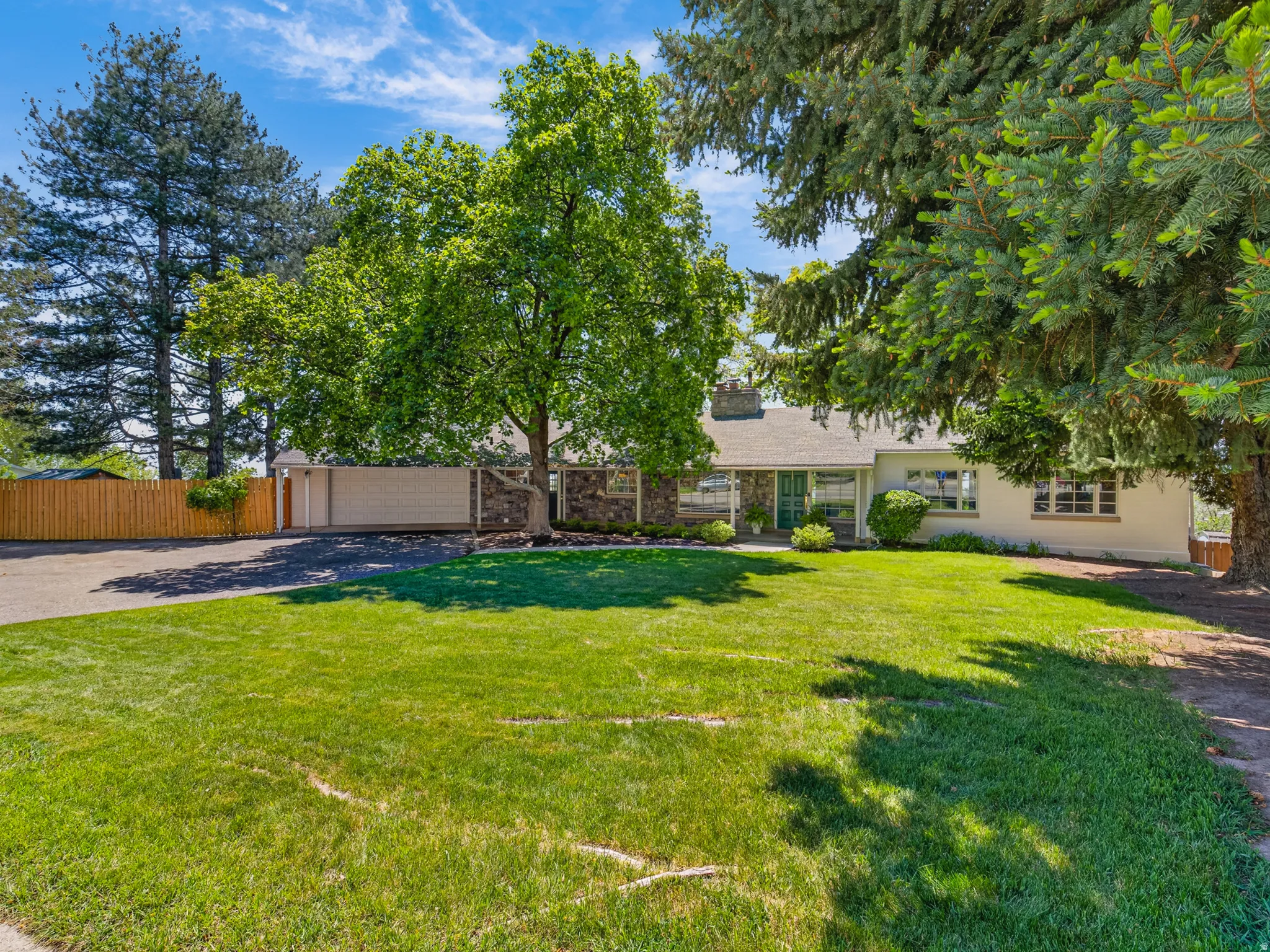 Spacious front yard with mature trees and a manicured lawn