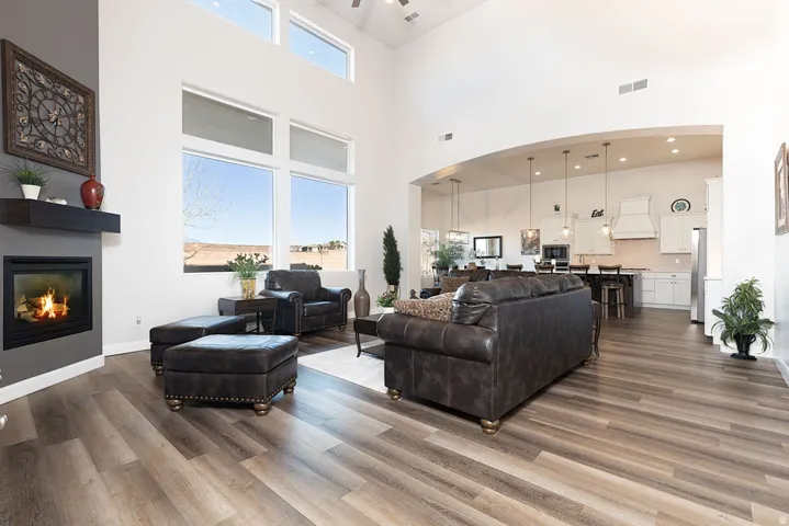 Living room featuring a glass covered fireplace, arched walkways, dark wood-type flooring, and a high ceiling