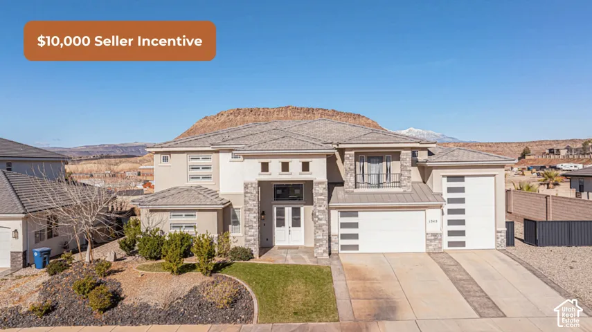 Contemporary multi-level exterior featuring stucco siding, stone veneer accents, multi-pane garage doors, and a second-story balcony