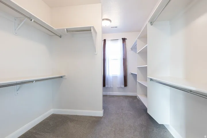 Walk in closet with dark carpet