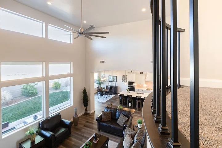 Living area with a high ceiling, recessed lighting, a ceiling fan, and dark wood finished floors
