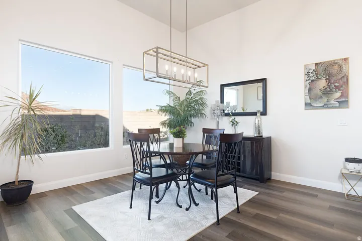 Dining area featuring dark wood finished floors, healthy amount of natural light, and hanging lights