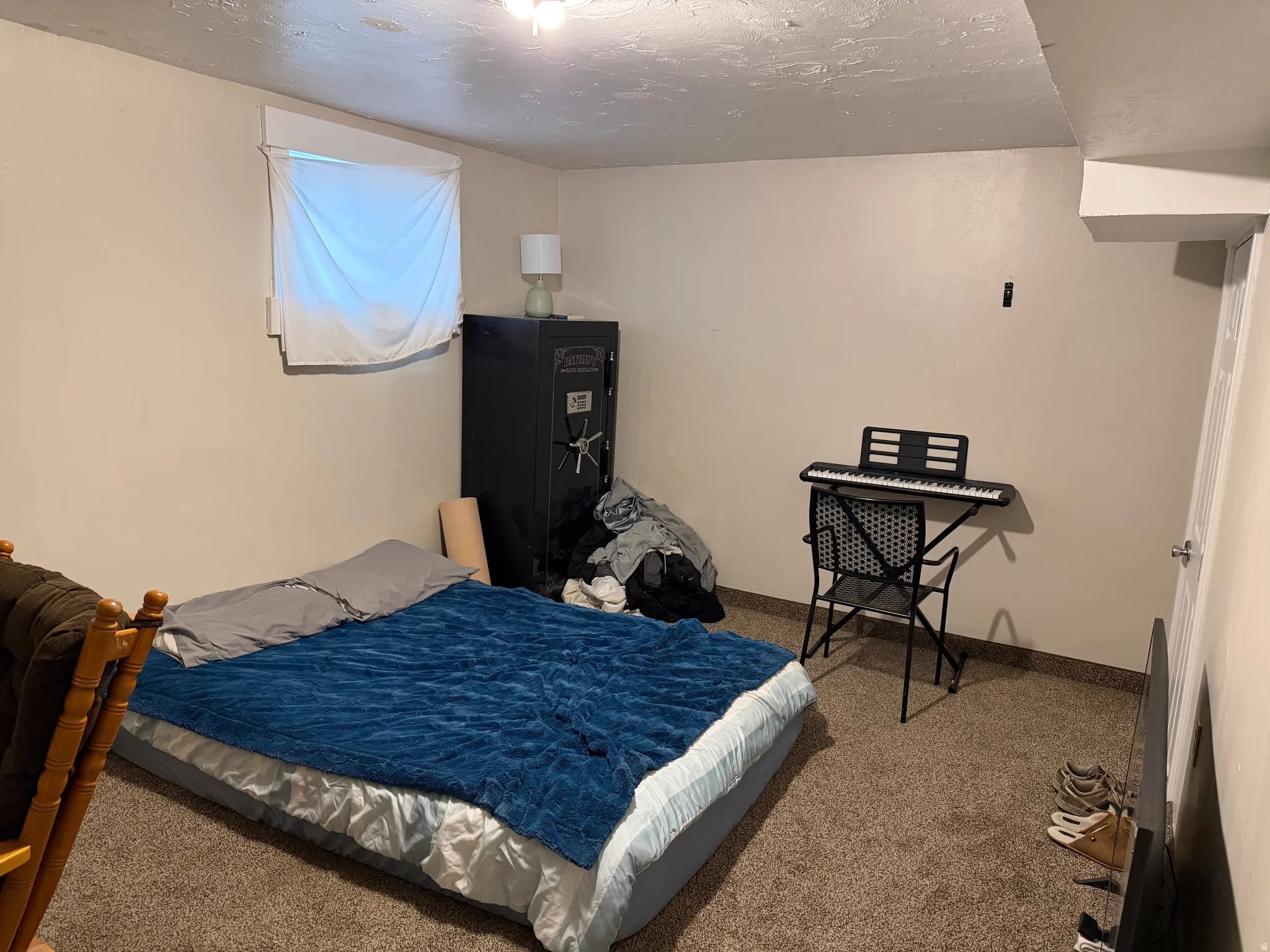 Carpeted bedroom with a textured ceiling and baseboards