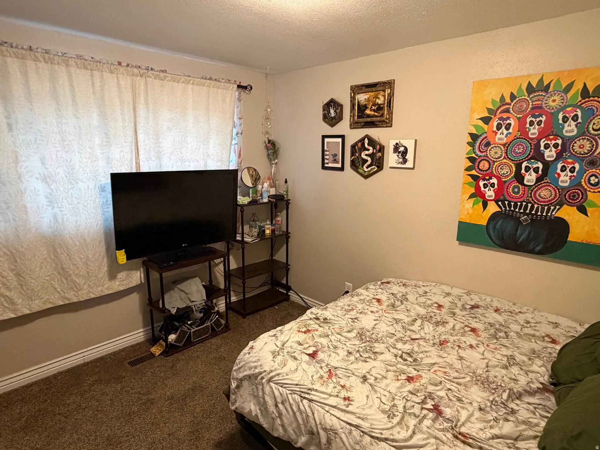 Bedroom with a textured ceiling and dark colored carpet