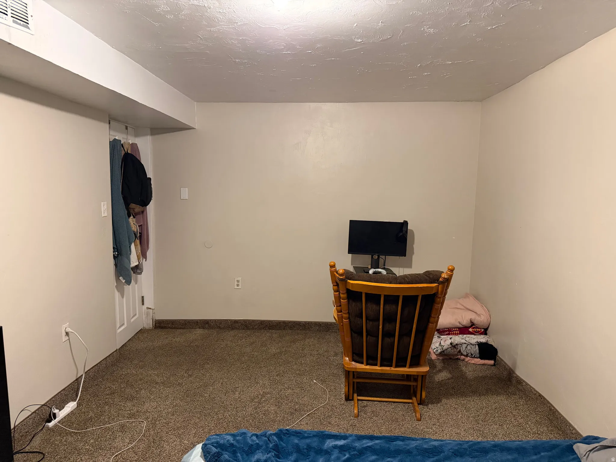 Bedroom featuring dark colored carpet and a textured ceiling