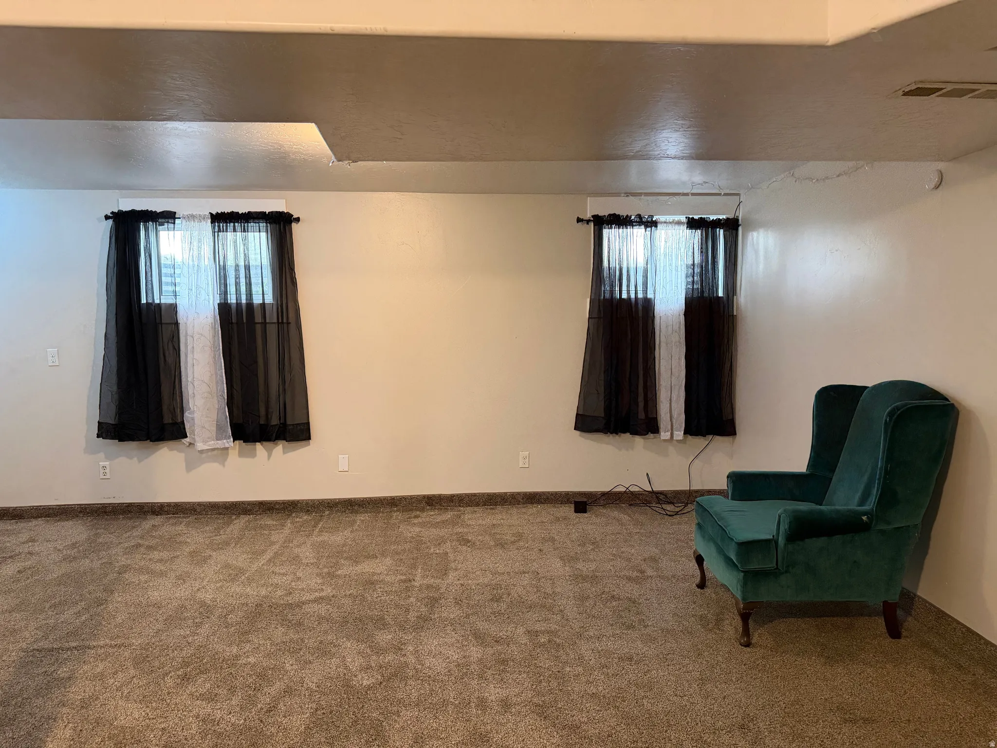 Living area featuring carpet flooring and baseboards