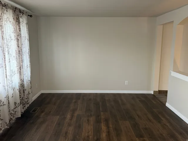 Spare room featuring dark wood-style floors and arched walkways