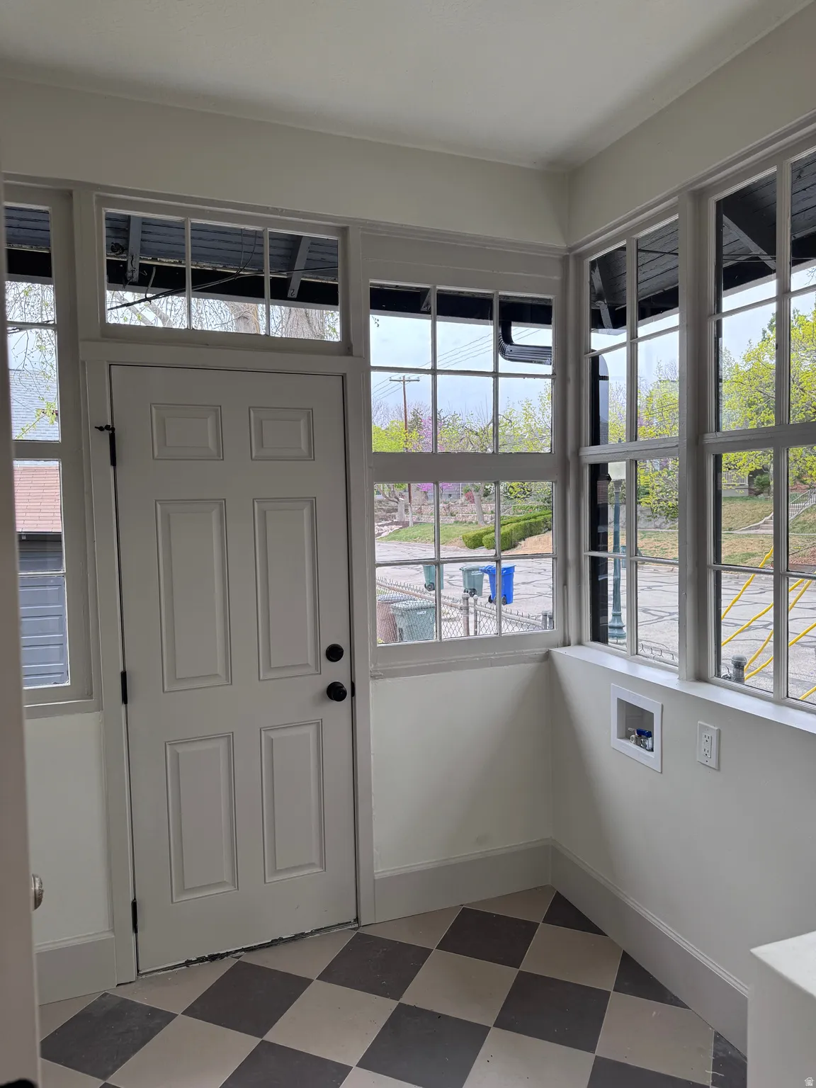 Foyer entrance with light floors and baseboards