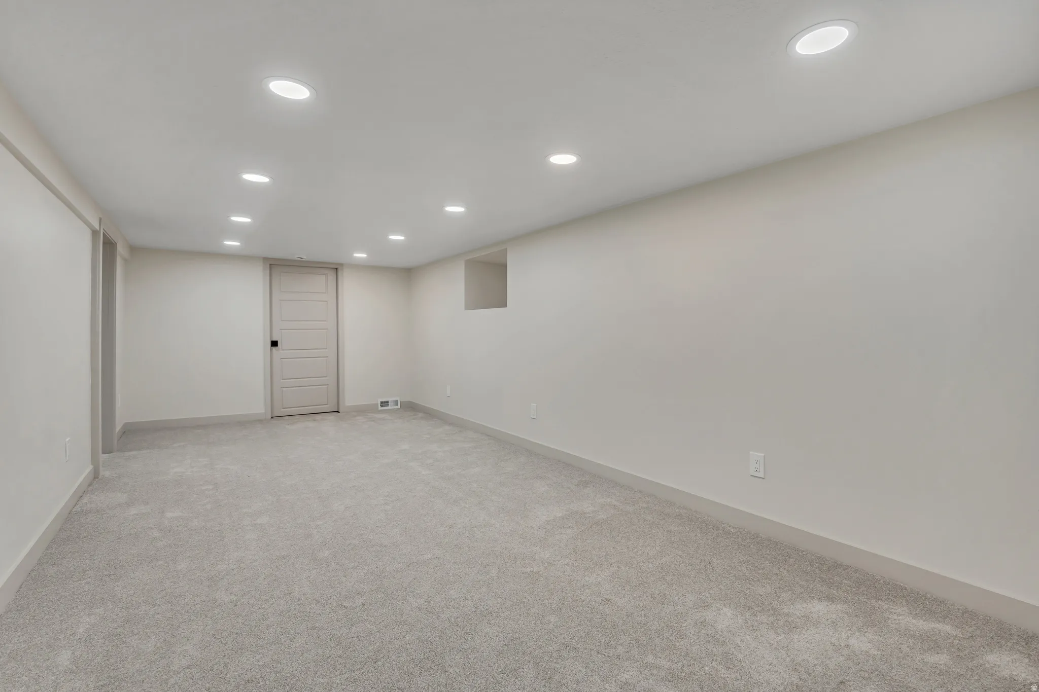 Finished below grade area featuring recessed lighting and light colored carpet