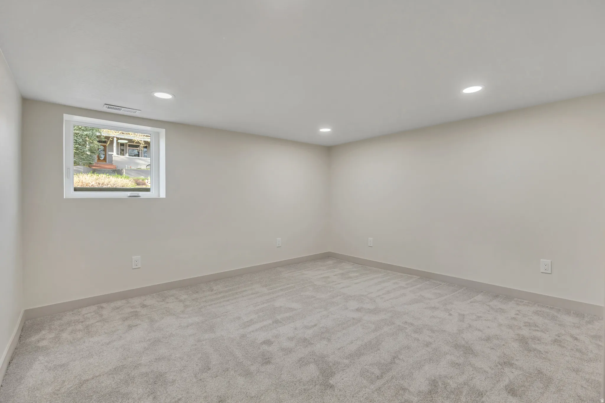 Empty room featuring light carpet and recessed lighting