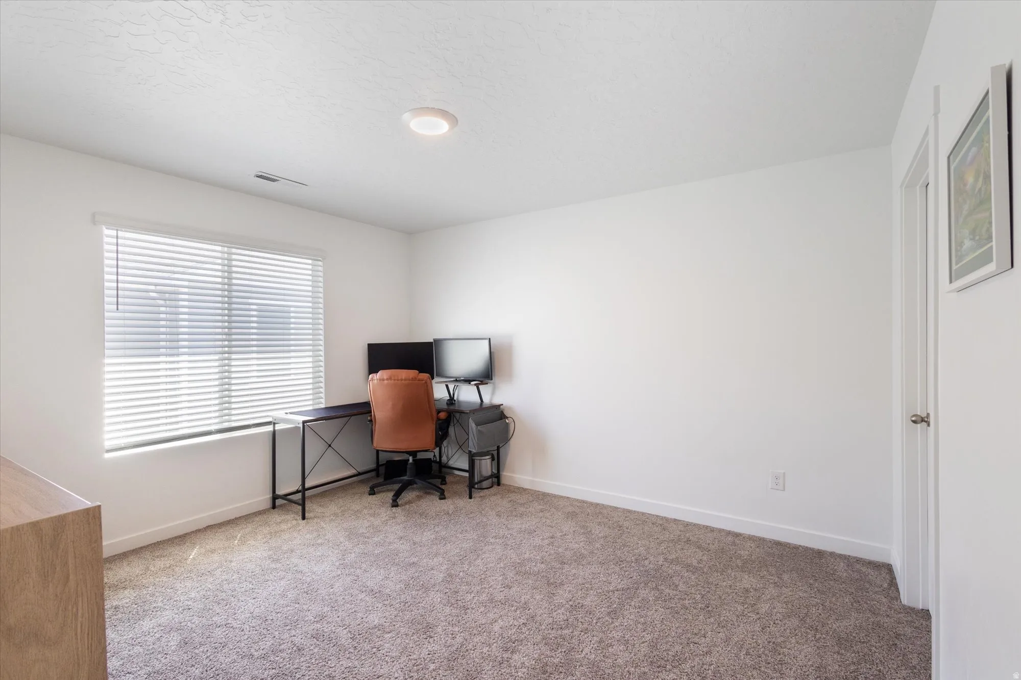 Office area with baseboards and light carpet