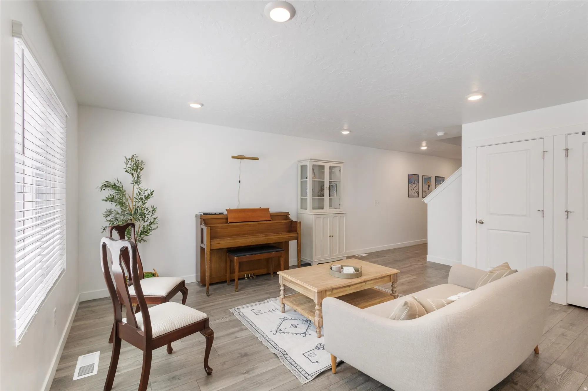 Living area with light wood-style flooring and recessed lighting