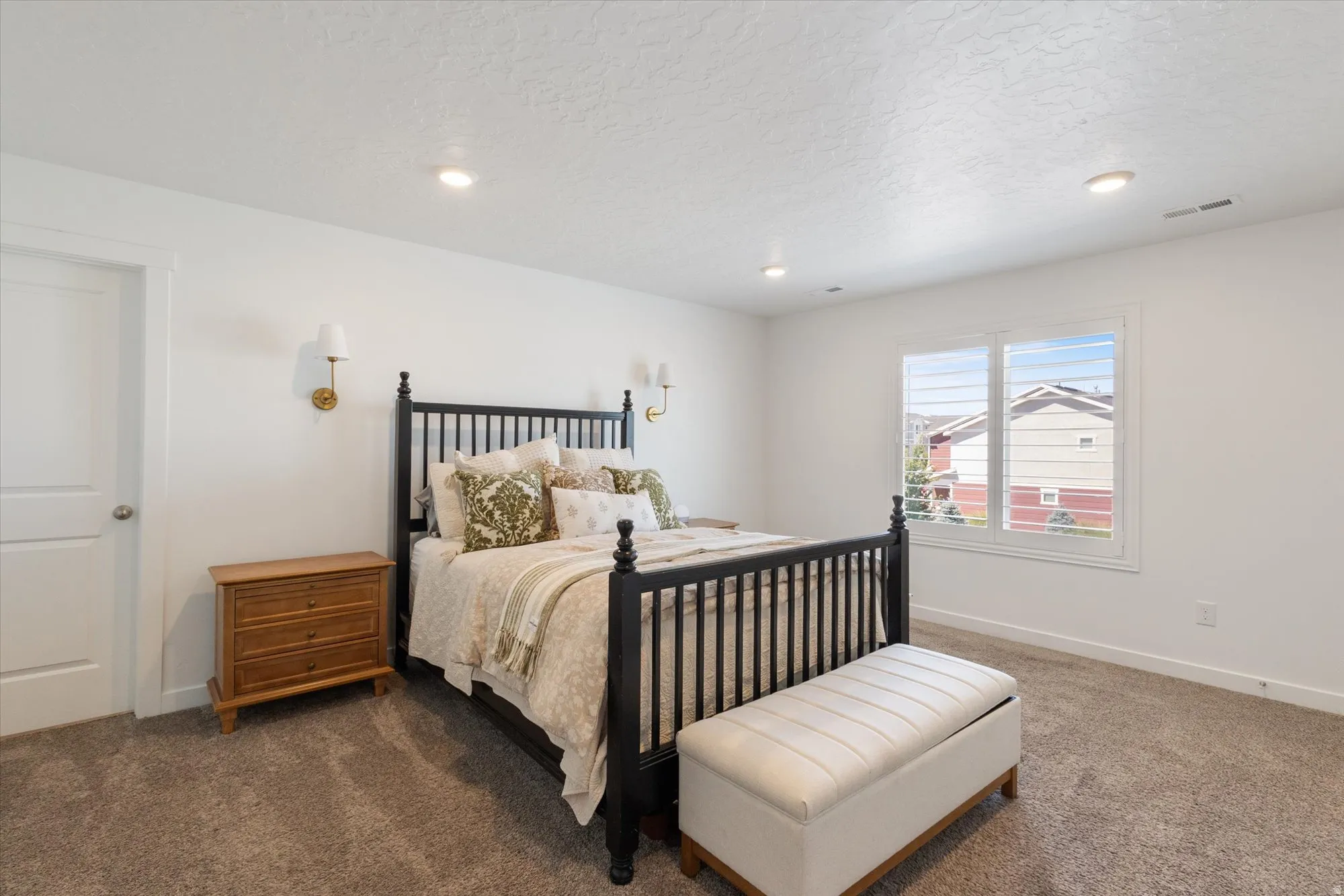 Carpeted bedroom with a textured ceiling and recessed lighting