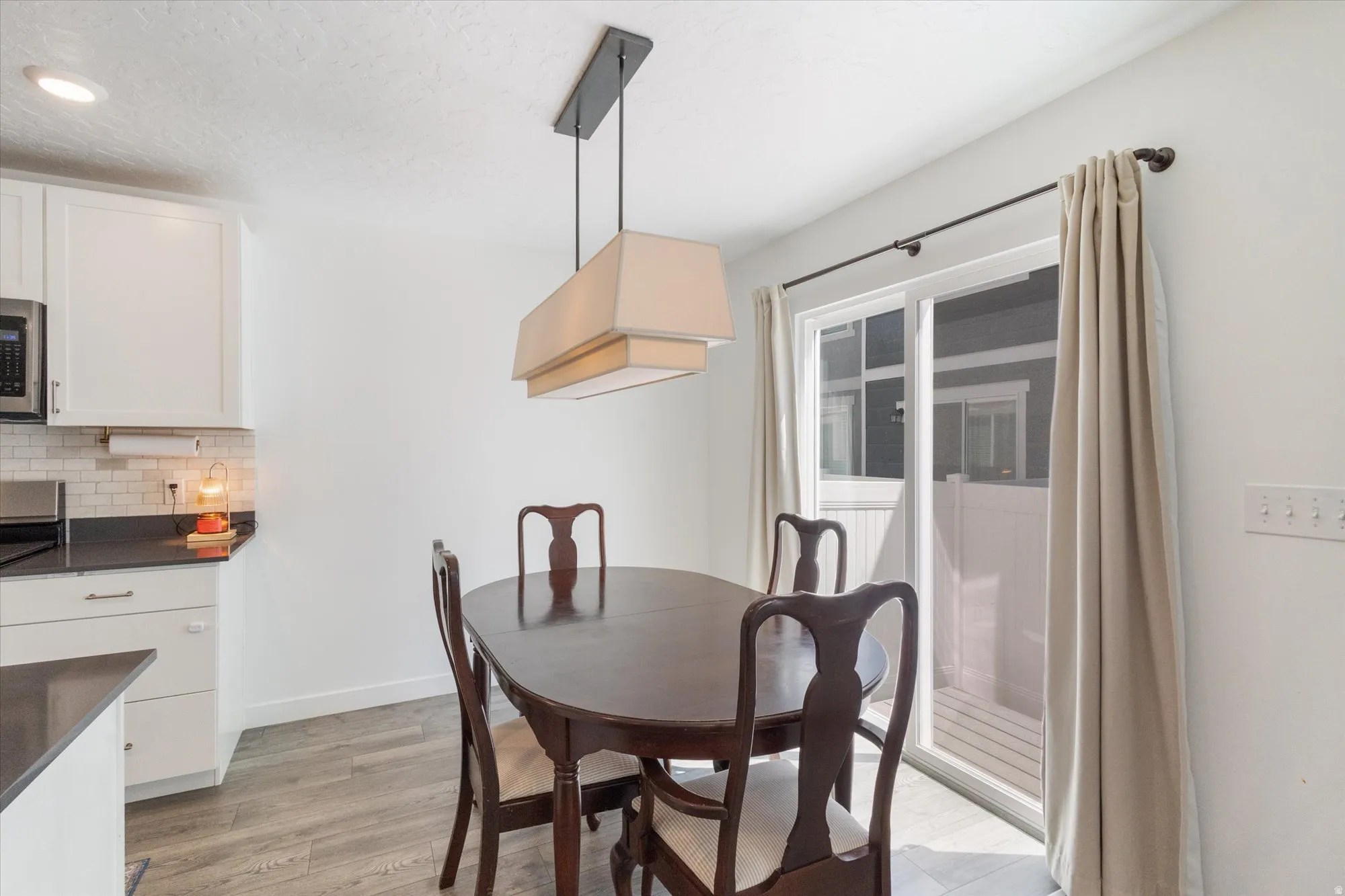 Dining space featuring light wood-style floors and a textured ceiling